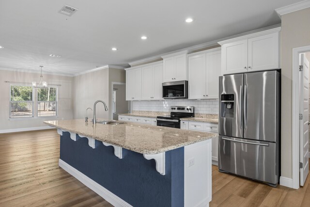 kitchen with a center island with sink, white cabinets, sink, and appliances with stainless steel finishes