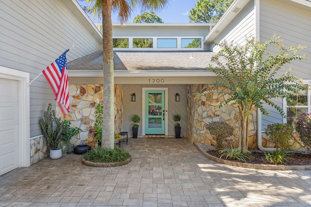 view of exterior entry with covered porch and a garage