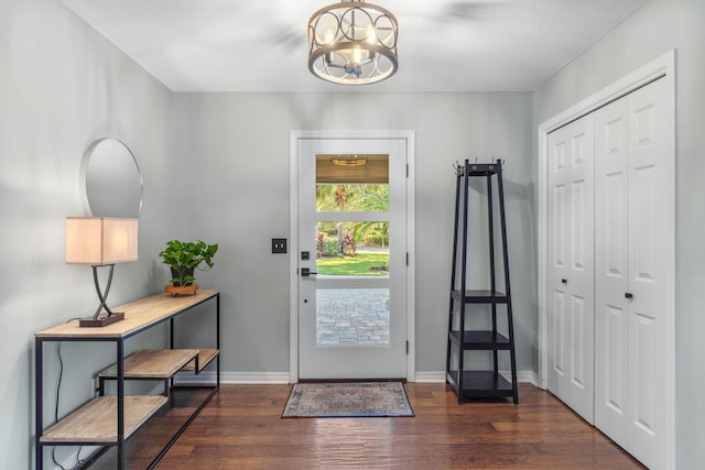 foyer with dark hardwood / wood-style flooring and an inviting chandelier