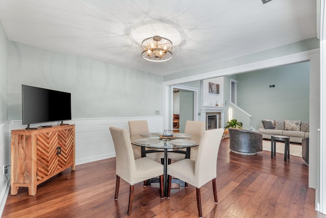 dining room featuring hardwood / wood-style floors, a fireplace, and a chandelier