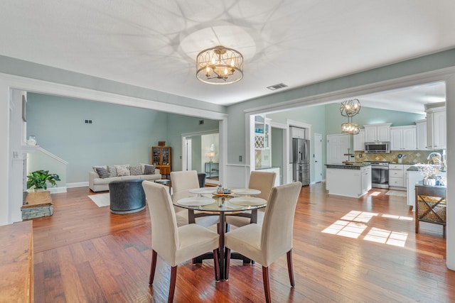 dining room with wood-type flooring and lofted ceiling