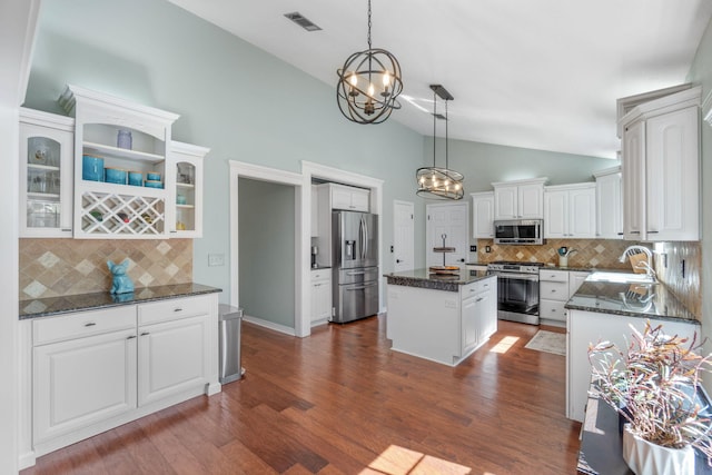 kitchen featuring a kitchen island, white cabinetry, dark wood-type flooring, pendant lighting, and stainless steel appliances