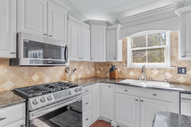 kitchen featuring backsplash, sink, appliances with stainless steel finishes, and white cabinets