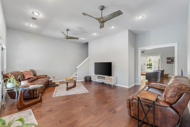 living room featuring a textured ceiling, ceiling fan, and dark hardwood / wood-style flooring