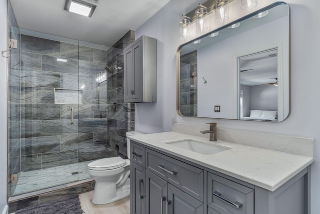 bathroom featuring toilet, hardwood / wood-style floors, walk in shower, and vanity