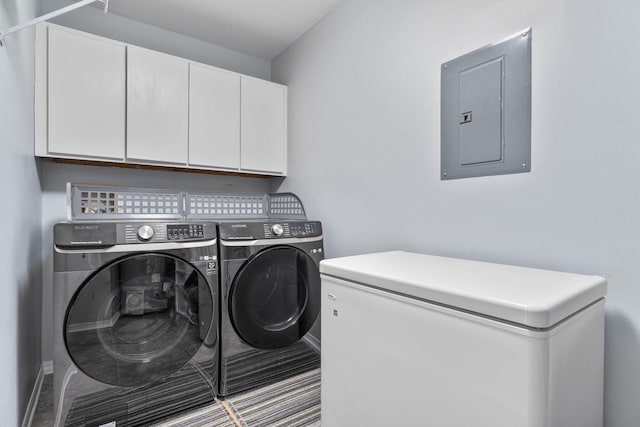 washroom with electric panel, cabinets, and washer and clothes dryer