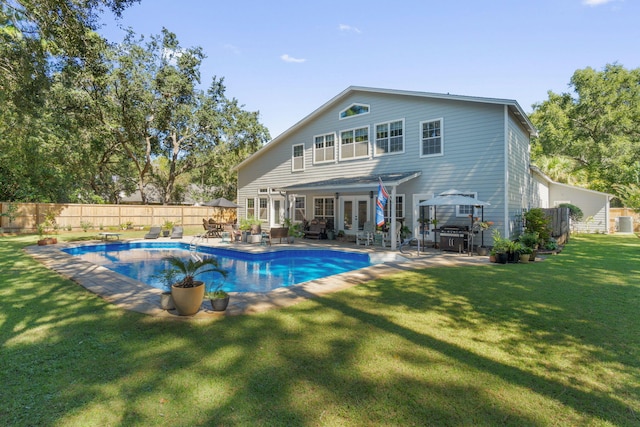 back of house featuring a yard, a patio, and a fenced in pool