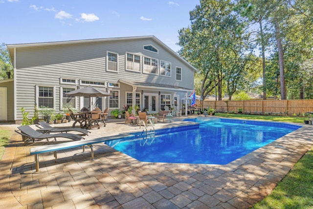 view of swimming pool with french doors, a diving board, and a patio area