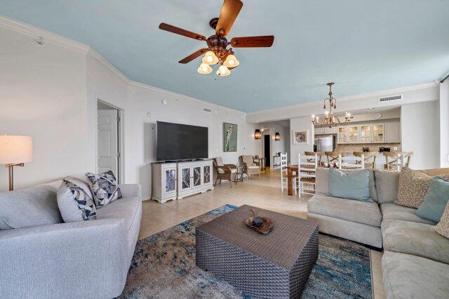 living room with crown molding and ceiling fan with notable chandelier