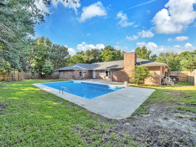 view of swimming pool featuring a patio area and a lawn