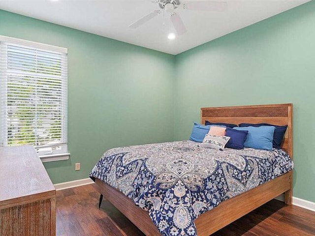 bedroom with dark hardwood / wood-style flooring, multiple windows, and ceiling fan