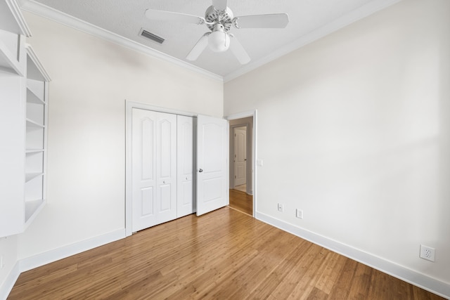 unfurnished bedroom featuring wood-type flooring, ceiling fan, and ornamental molding