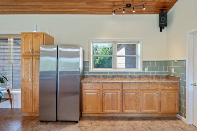 kitchen featuring stainless steel fridge, tasteful backsplash, light tile patterned floors, and wood ceiling