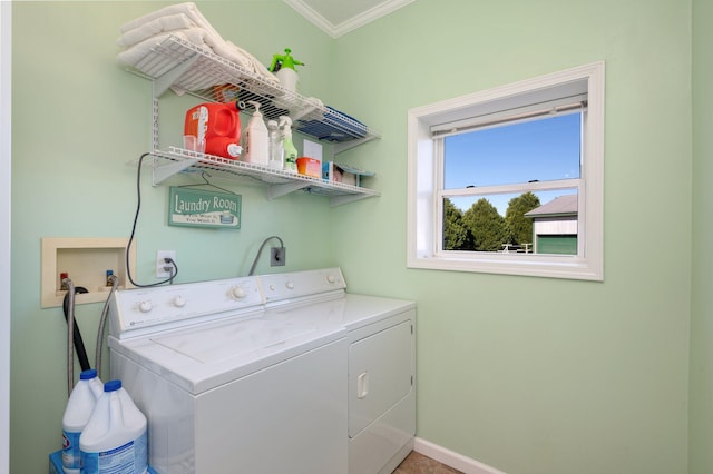 clothes washing area with washing machine and clothes dryer and crown molding