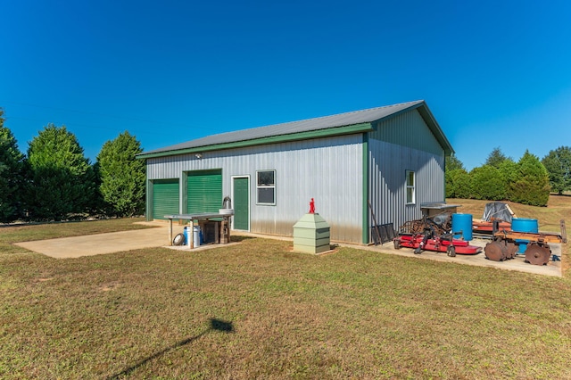 back of house with a lawn and an outdoor structure