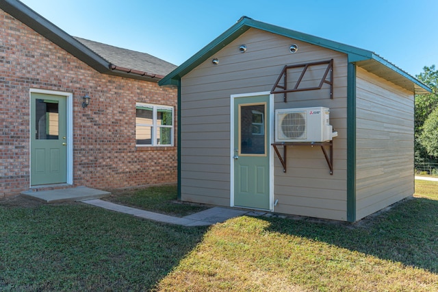 view of outbuilding with ac unit and a yard