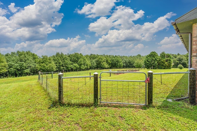 view of gate with a yard and a rural view