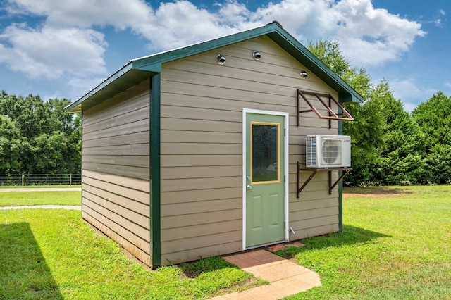 view of outdoor structure featuring a lawn and ac unit