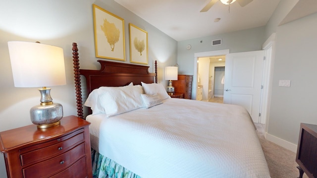 bedroom featuring ensuite bath, light colored carpet, and ceiling fan