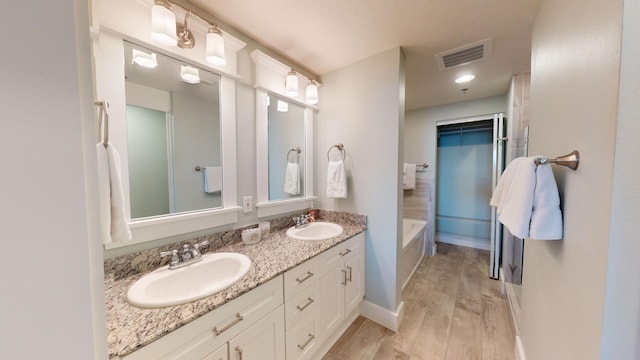 bathroom featuring vanity, wood-type flooring, and a washtub