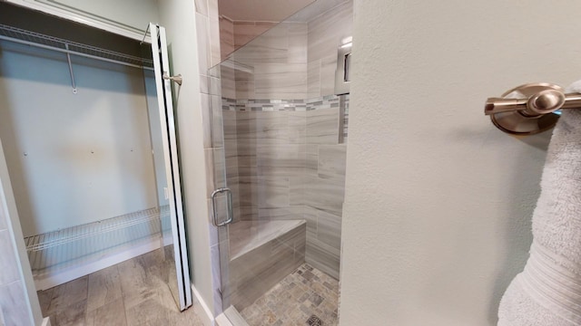 bathroom with hardwood / wood-style flooring and walk in shower