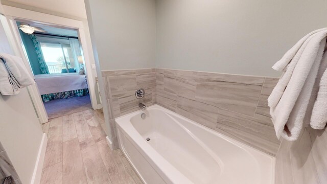 bathroom with a bathing tub and hardwood / wood-style floors