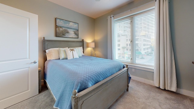 bedroom featuring light carpet and multiple windows