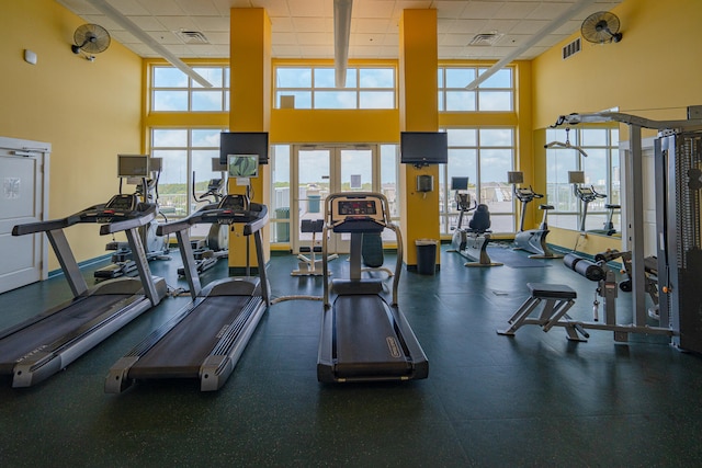 exercise room featuring a drop ceiling and a high ceiling