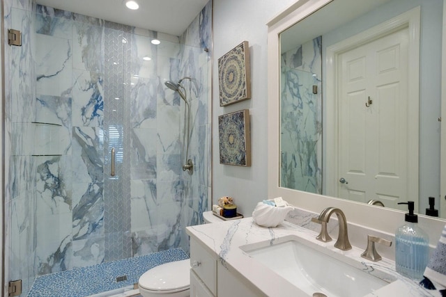 bathroom featuring toilet, a shower with door, and vanity