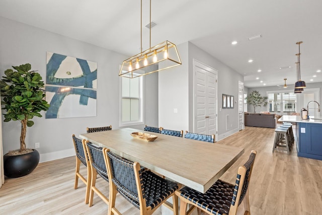 dining room with sink and light wood-type flooring