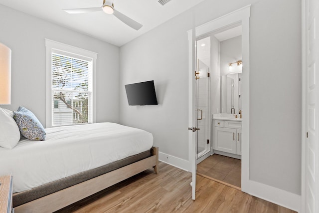 bedroom with light hardwood / wood-style floors, ensuite bath, and ceiling fan