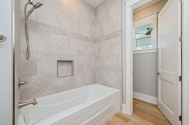 bathroom with wood-type flooring and tiled shower / bath