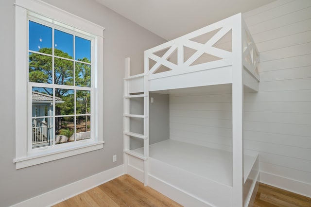 unfurnished bedroom featuring multiple windows and hardwood / wood-style flooring