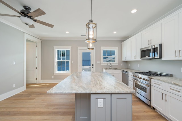 kitchen with white cabinetry, a center island, light hardwood / wood-style floors, and appliances with stainless steel finishes