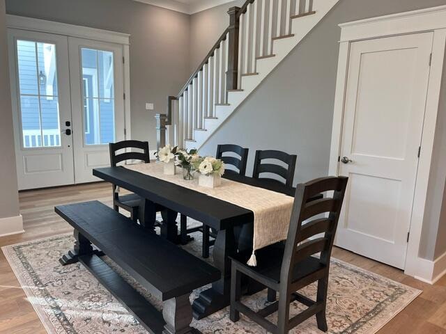 dining area with french doors and light hardwood / wood-style floors