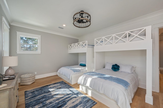 bedroom with ornamental molding and light hardwood / wood-style flooring