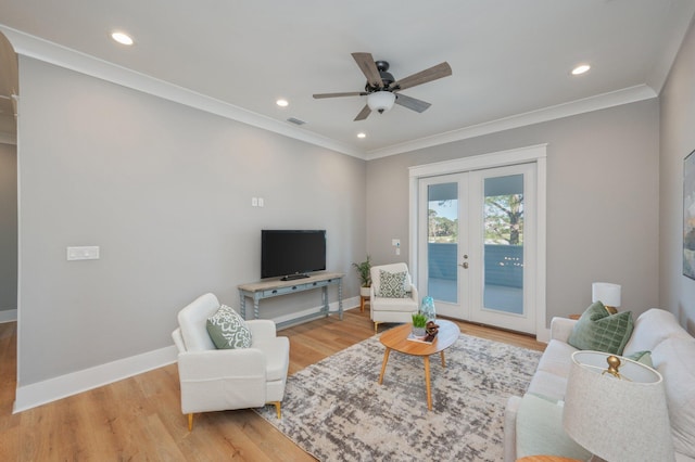 living room featuring ceiling fan, french doors, ornamental molding, and light wood-type flooring