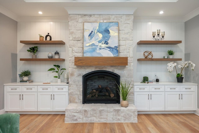 unfurnished living room featuring a fireplace, light hardwood / wood-style floors, and ornamental molding