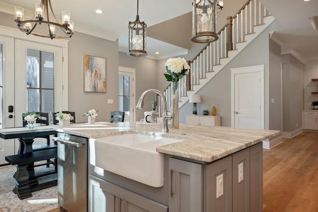 kitchen featuring crown molding, sink, stainless steel dishwasher, gray cabinets, and light hardwood / wood-style floors