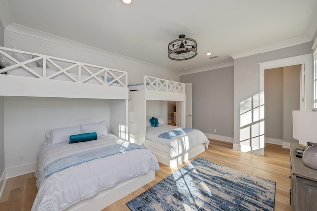 bedroom with light wood-type flooring and crown molding