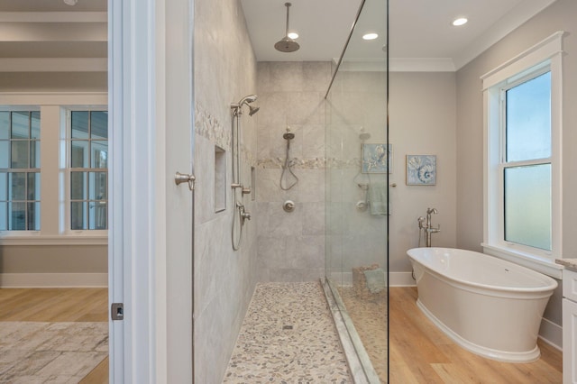 bathroom featuring ornamental molding, shower with separate bathtub, and hardwood / wood-style flooring