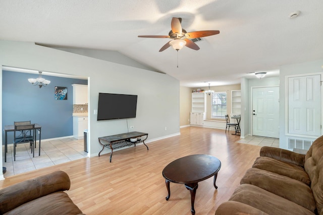 living room with ceiling fan with notable chandelier, light hardwood / wood-style floors, and lofted ceiling