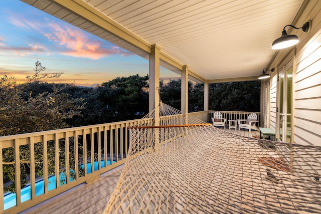 deck at dusk with a pool