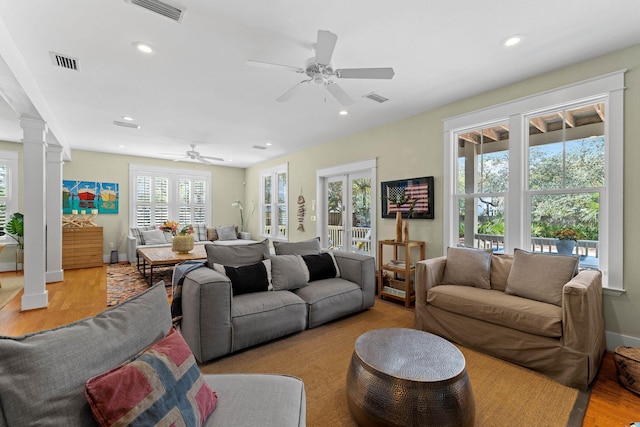 living room with ceiling fan, ornate columns, light hardwood / wood-style floors, and plenty of natural light