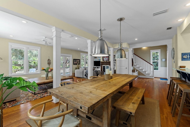 dining room with ornate columns, ceiling fan, and dark hardwood / wood-style flooring