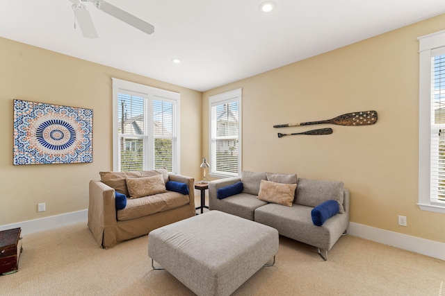 living room featuring a wealth of natural light, light carpet, and ceiling fan