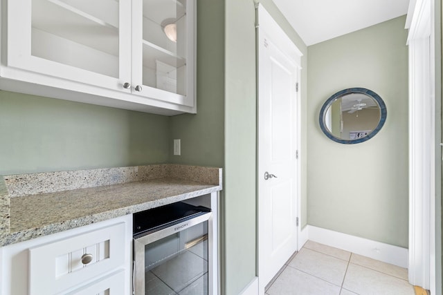 bar with white cabinetry, beverage cooler, and light tile patterned floors