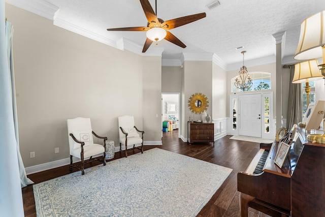 entrance foyer featuring crown molding, a healthy amount of sunlight, dark wood-type flooring, and ceiling fan with notable chandelier