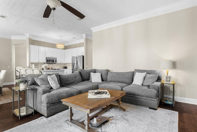 living room with crown molding, a textured ceiling, dark wood-type flooring, and ceiling fan