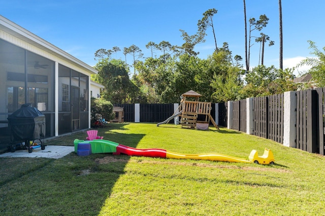 view of yard featuring a sunroom and a playground